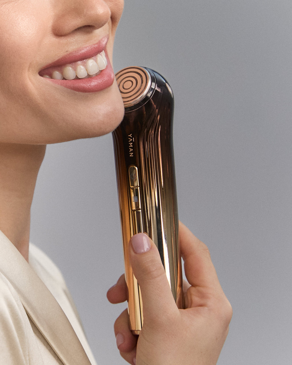 Close-up of a smiling model holding Bloom 6 at her chin