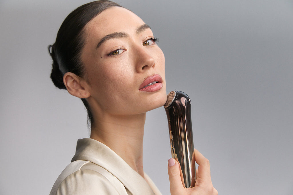 Model looking at camera with Bloom 6 at her jaw
