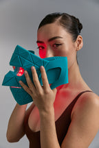Blue Green Mask Lift held to the face with red LEDs visible