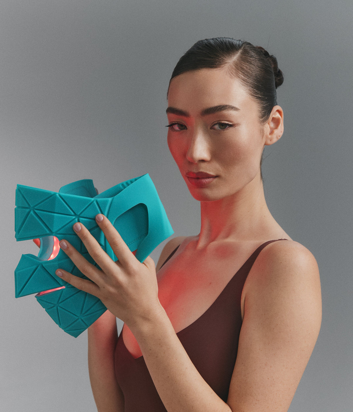 Model holding Blue Green Mask Lift, red light on
