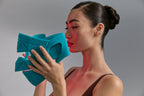 Model holding Blue Green Mask Lift in front of her face