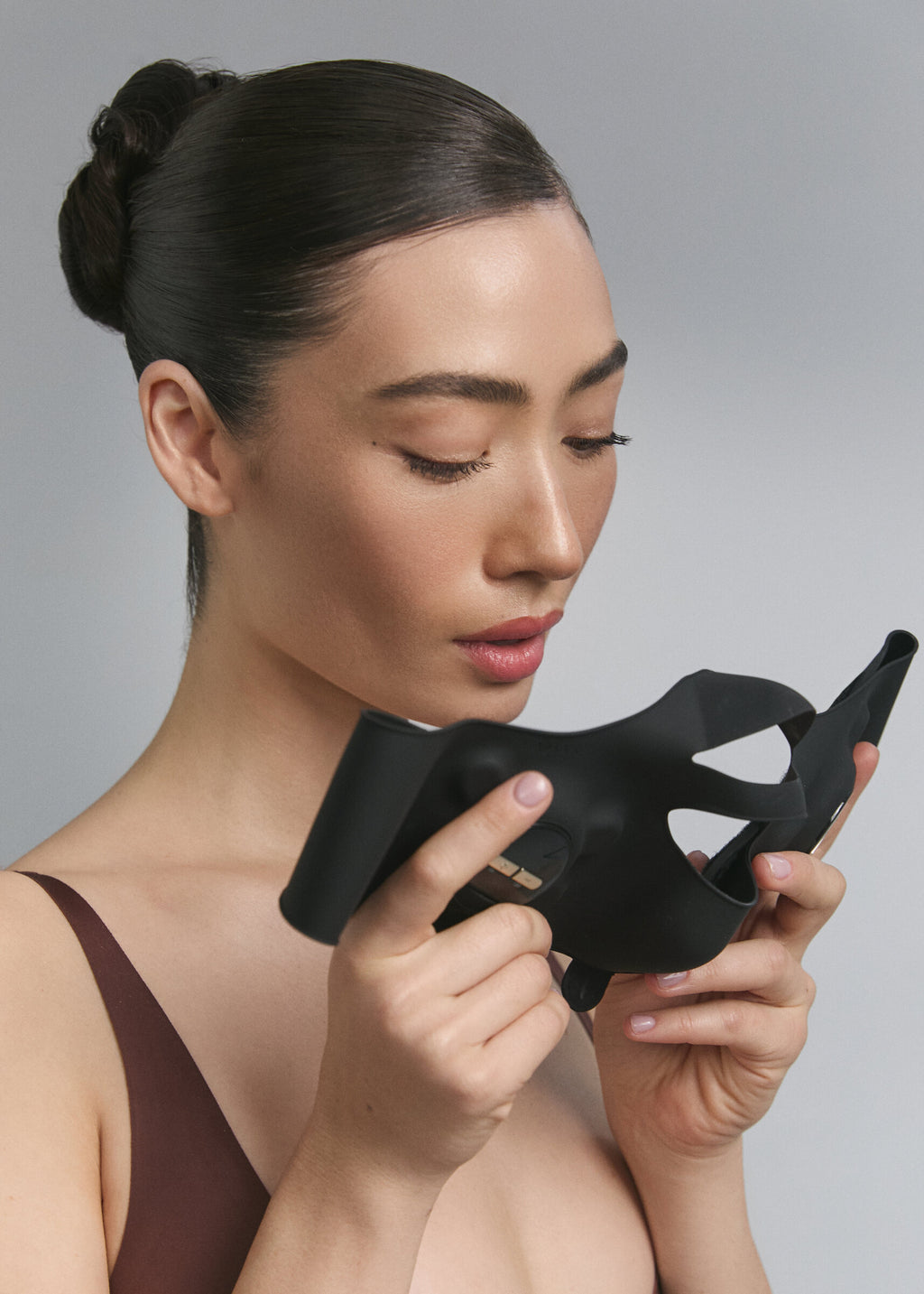 Model holding Medi Lift Plus EMS mask in both hands