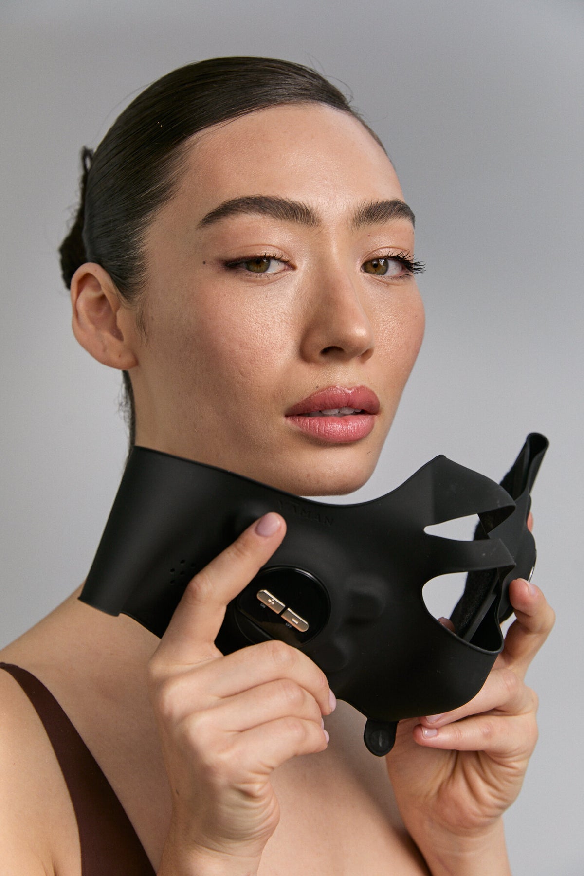 Model holding Medi Lift Plus mask below her chin