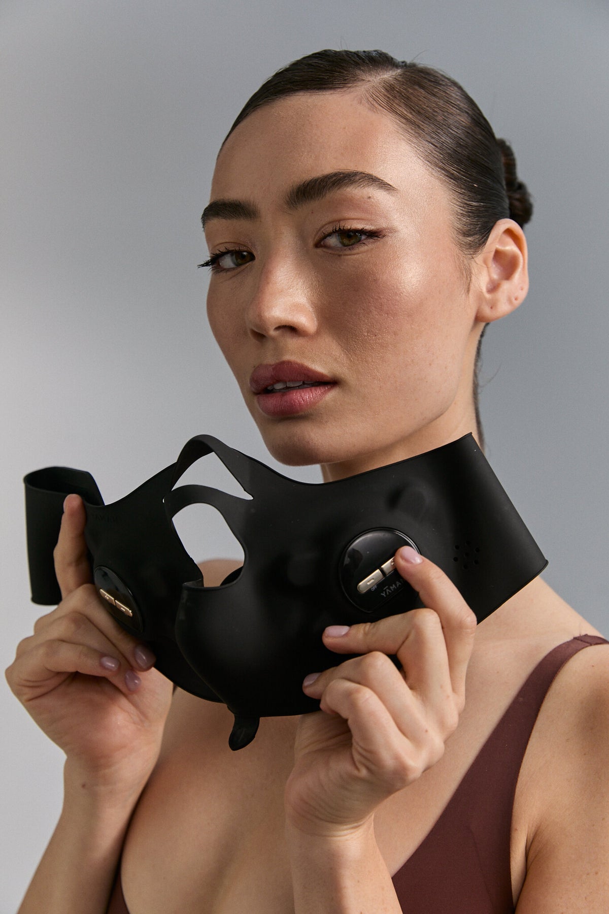 Model holding Medi Lift Plus mask against her face