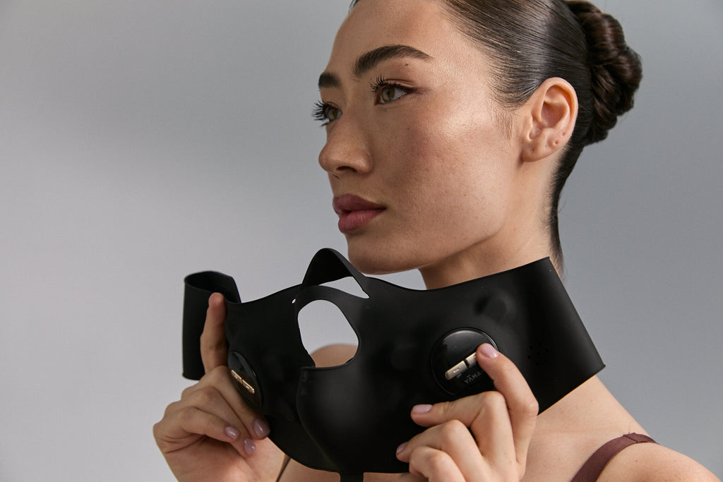 Model holding Medi Lift Plus mask at her jaw, landscape view