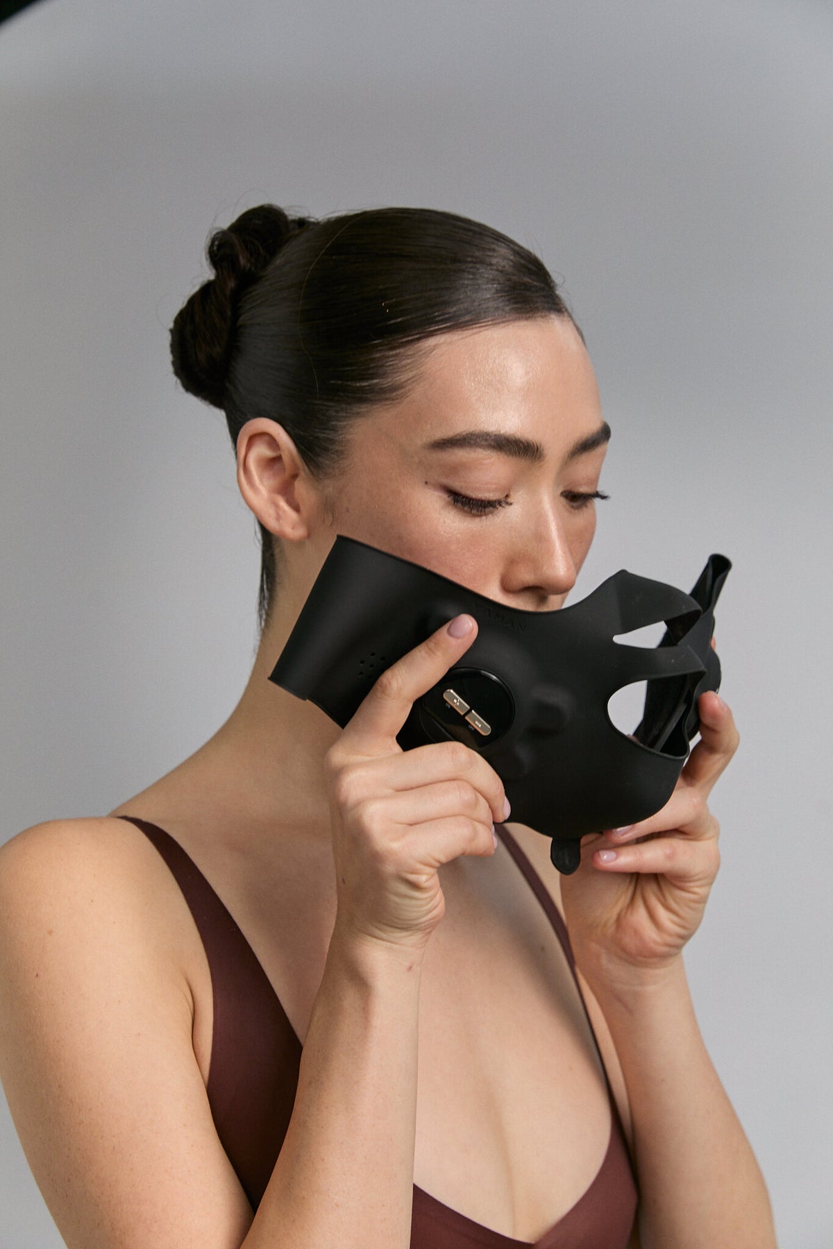 Model holding Medi Lift Plus mask close to her face