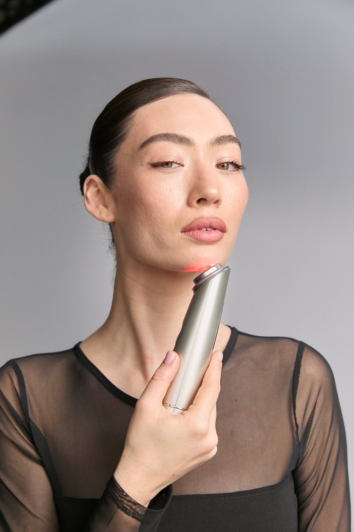 Model holding Photo Plus Shiny Neo below her chin