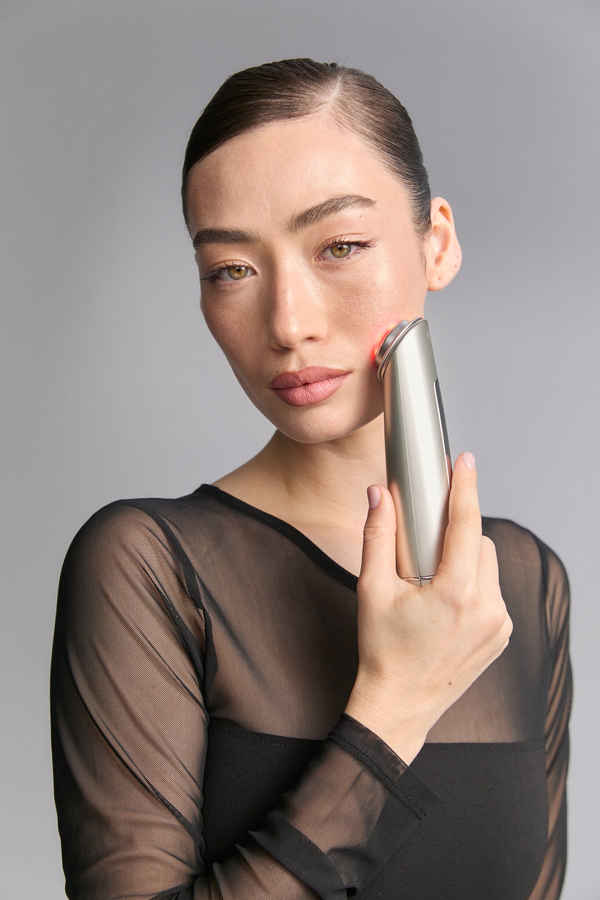 Model holding Photo Plus Shiny Neo upright beside her face