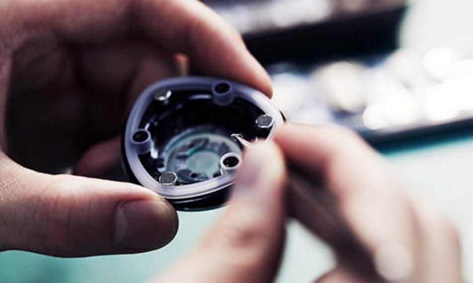 Hands assembling the head of a beauty device